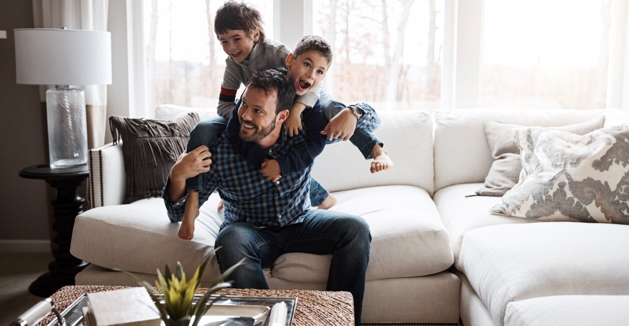 Father Playing With Children In Clean Home